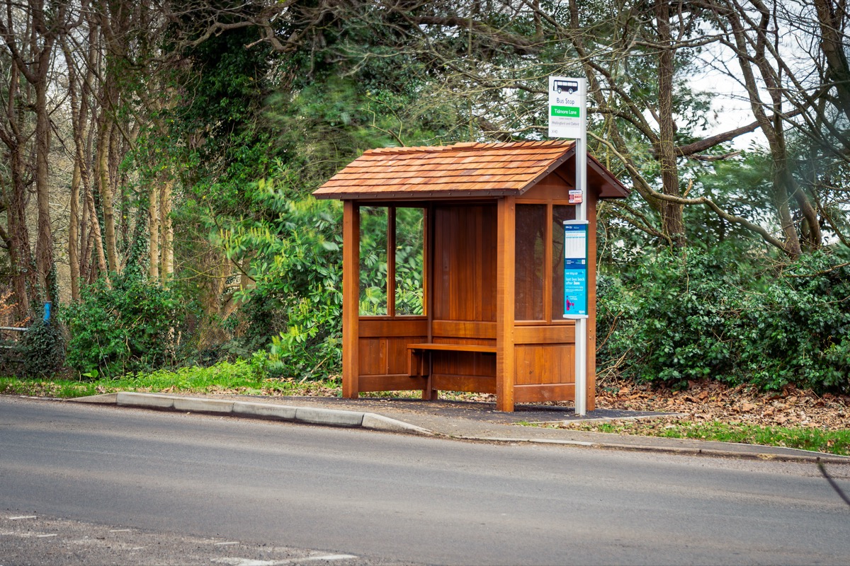 A hand-built Littlethorpe hardwood shelter with bench seating in a woodland setting.