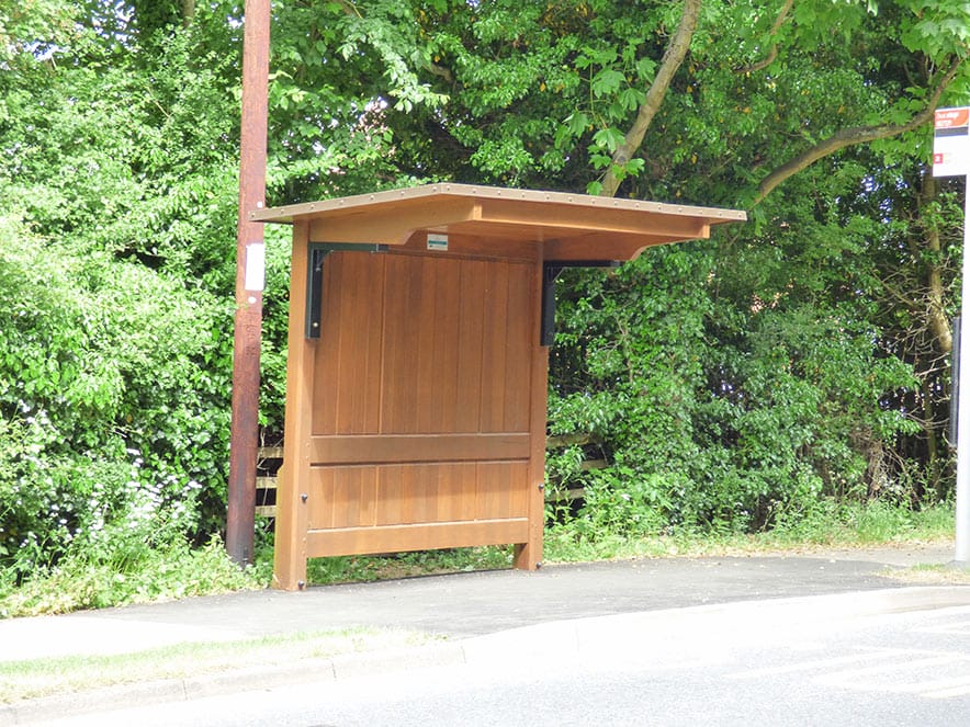 Cropston shelter installed beside a tree-lined roadside pavement.