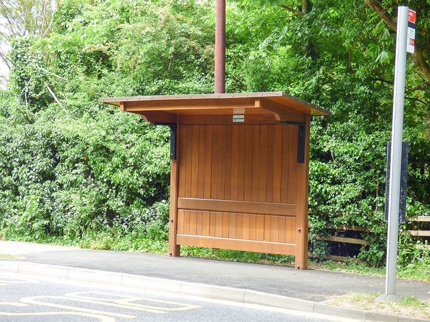 Installed Cropston cantilever shelter with boarded rear, narrow pavement and bus stop flag.